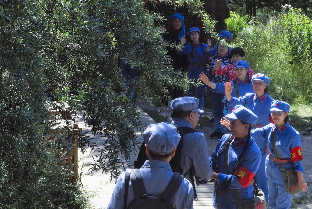 游客在六盤山腳下的“紅軍小道”，體驗紅軍出發時群眾（景區工作人員扮演）與紅軍依依惜別的情景（8月12日攝）。