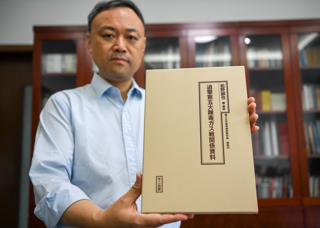 9月3日，侵華日軍南京大屠殺遇難同胞紀念館館長張建軍展示《迫擊第五大隊毒氣戰相關資料》一書。