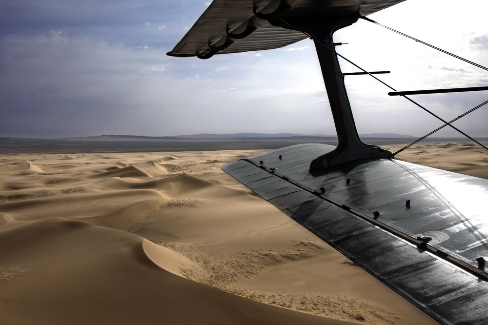 6月9日，西部戰區空軍運輸搜救航空兵某團運-5型運輸機在沙漠深處展開超低空飛播作業。