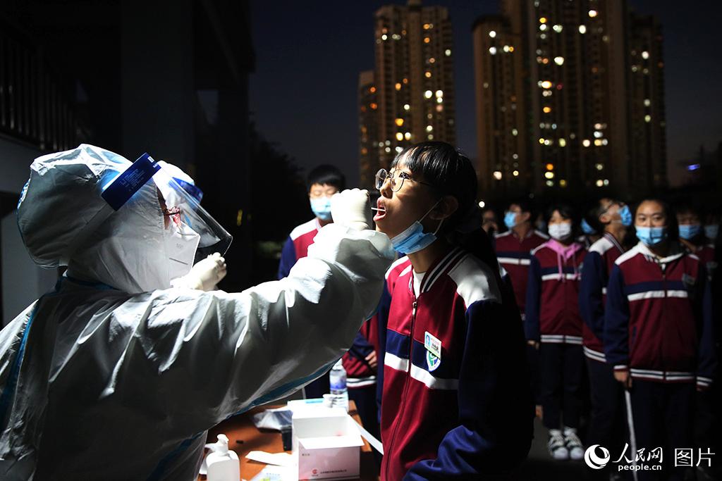 10月12日，檢測人員連夜在青島經濟技術開發區第四中學對該校學生進行免費核酸檢測。張進剛/ 攝