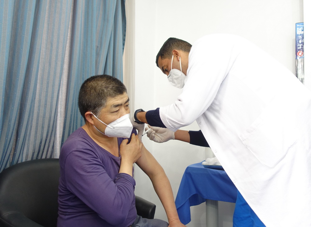 4月14日，在突尼斯首都突尼斯市，醫務人員為一名中國公民接種新冠疫苗。