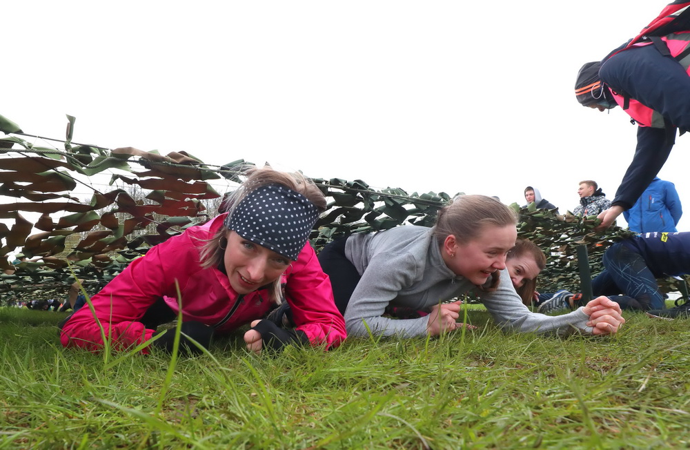 5月8日，在白俄羅斯明斯克舉行的“勇敢者賽跑”活動上，選手們從偽裝網下爬過。