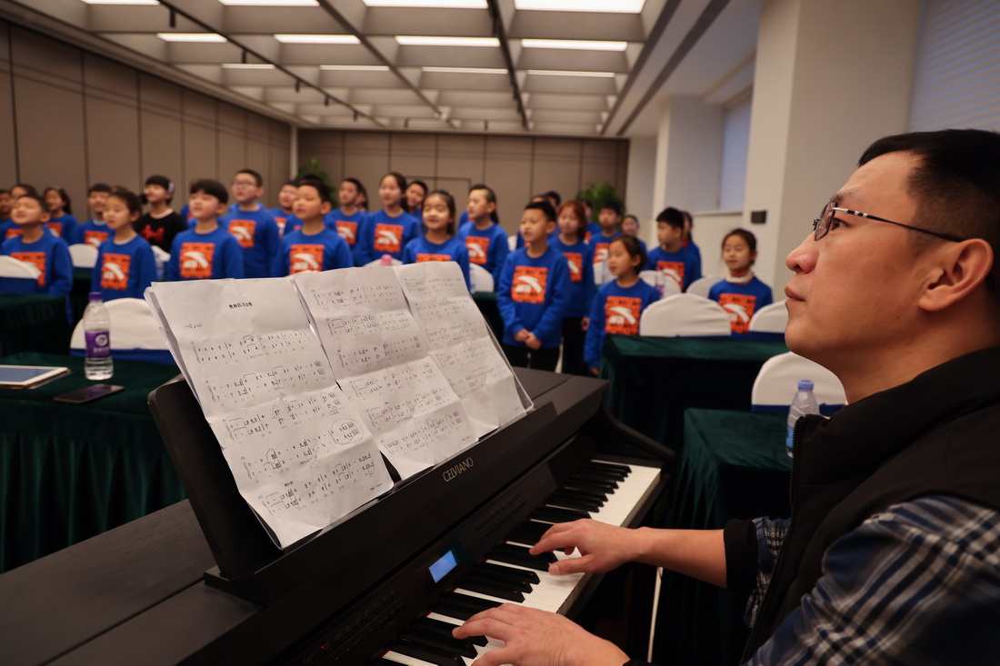 保定學院音樂舞蹈學院聲樂教師王金山（右）與馬蘭花兒童合唱團在酒店會議室排練（1月11日攝）。新華社記者 許雅楠 攝