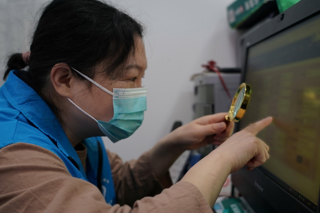 在北京市海淀區八里莊街道首師大社區居委會，馬爾東手握放大鏡進行疫情防控信息統計工作（5月13日攝）。新華社記者 任超 攝
