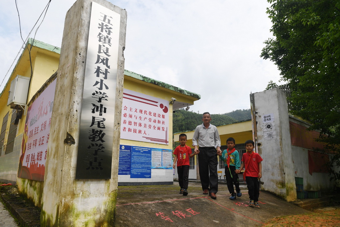 在廣西賀州市昭平縣五將鎮良風村小學沖尾教學點，龔壽新老師領著學生走出校門（5月25日攝）。
