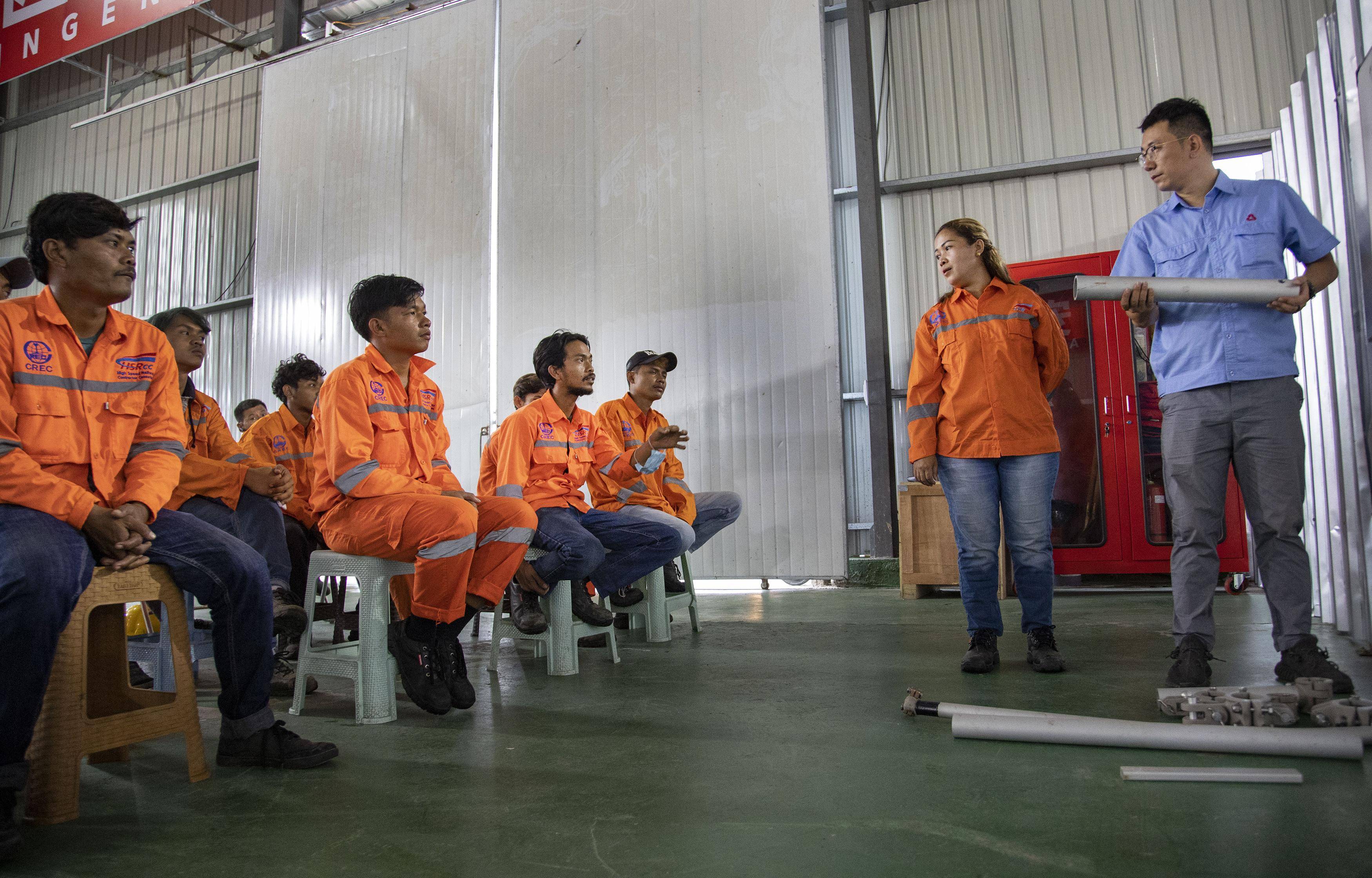 11月13日，在印度尼西亞萬隆，來自中國中鐵電氣化局的王浩（右一）向印尼員工講解中國標準“簡統化”接觸網裝配工藝。 新華社發 （焦宏濤 攝）