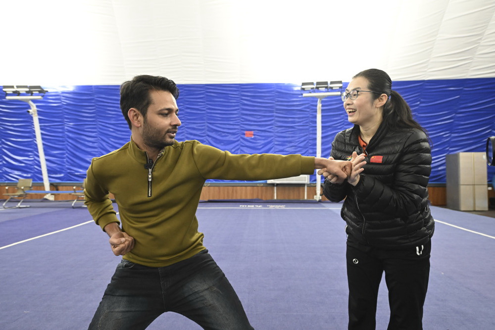 在天津市西青區精武鎮精武會館，霍靜虹指導穆罕默德·納比爾（左）練習“霍氏練手拳”（12月25日攝）。新華社記者 孫凡越 攝