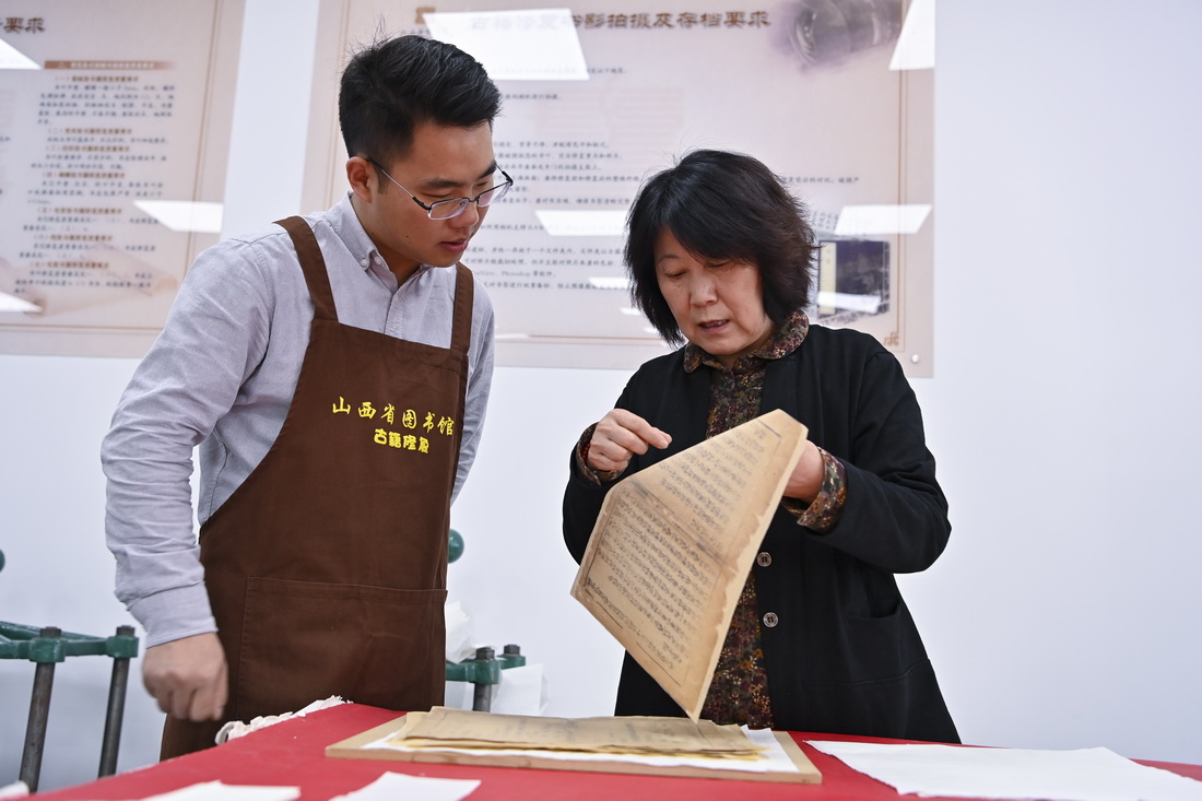 在山西省圖書館古籍修復中心，程文濤和修復導師邢雅梅（右）交流（4月21日攝）。新華社記者 楊晨光 攝