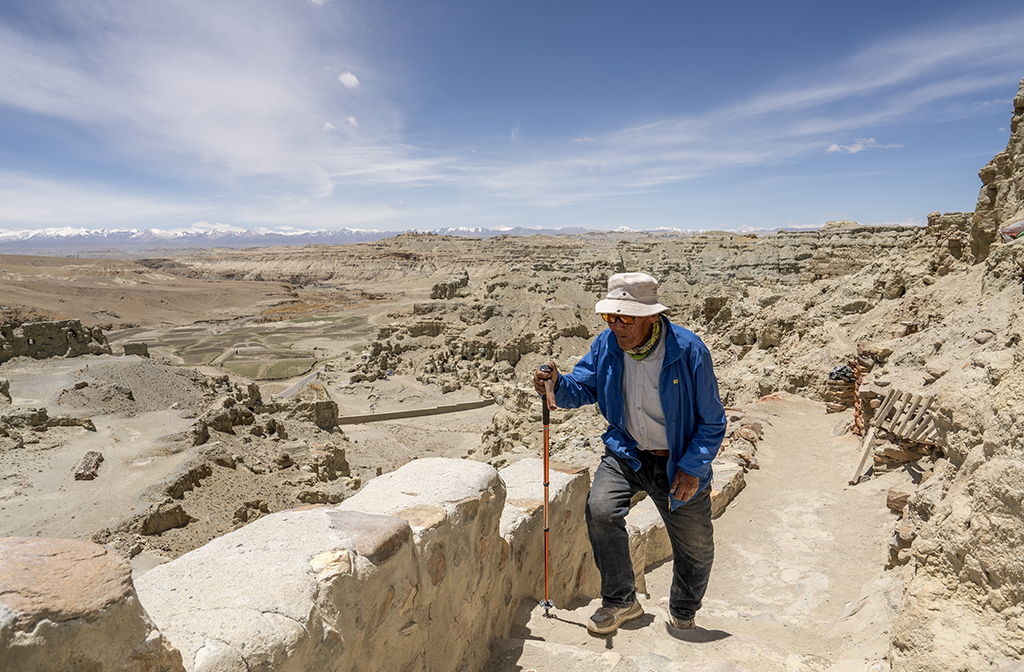 5月26日，仁增旺扎老人拄著拐棍在石窟間行走。新華社記者 費茂華 攝
