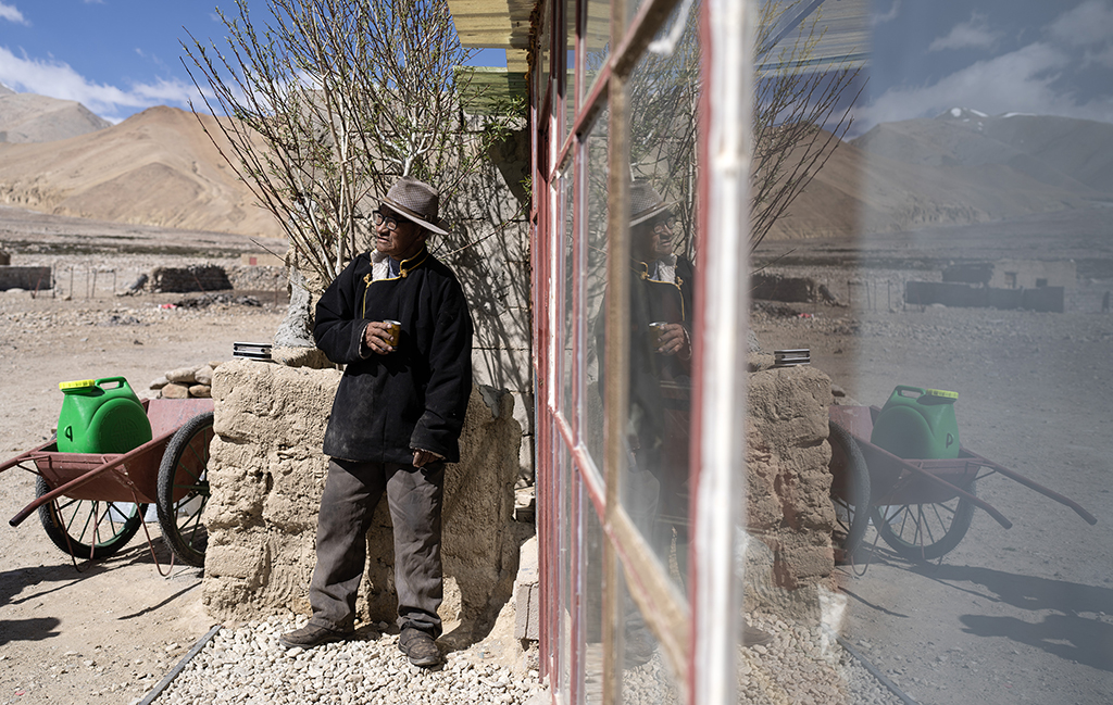 5月28日，洛桑占堆老人站在自己現在居住的房子前。這是他的第四個家，也是典角村的“三代房”。新華社記者 費茂華 攝