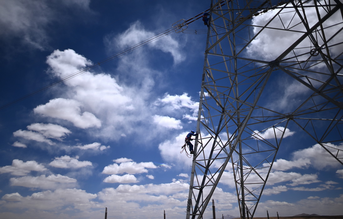 在青海省海西蒙古族藏族自治州格爾木市唐古拉山鎮境內，檢修人員在巡檢中（6月3日攝）。新華社記者 張宏祥 攝