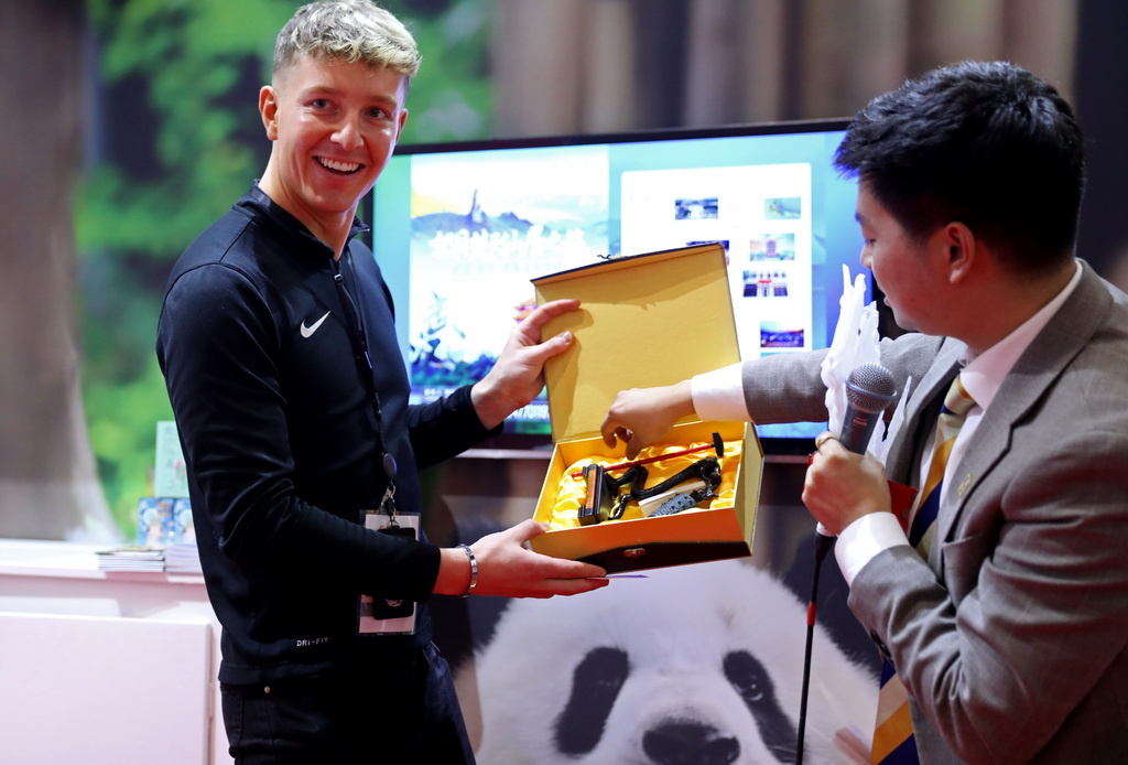 11月6日，在英國倫敦世界旅游交易會中國展區，一名男子獲得文創禮物。