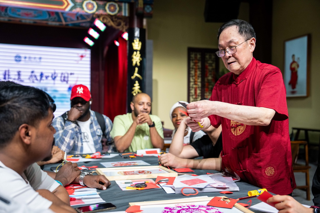 4月18日，在長沙非物質文化遺產館，非遺傳承人（右一）為留學生介紹剪紙技藝。
