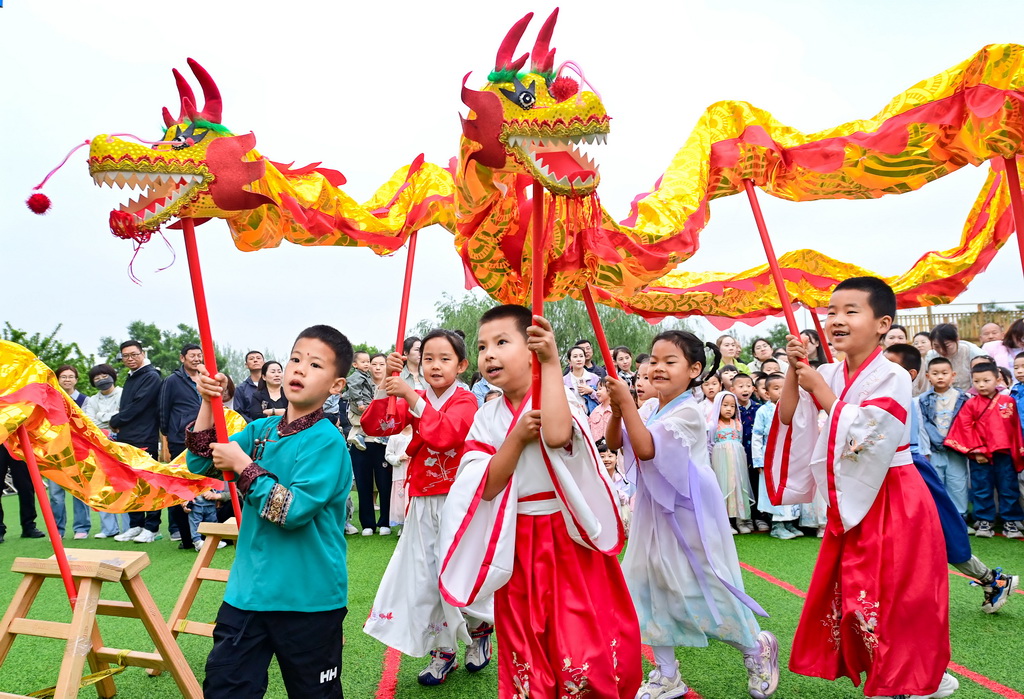 6月5日，內蒙古鄂爾多斯市康巴什區第十二幼兒園的孩子們在體驗舞龍。新華社發（王正攝）