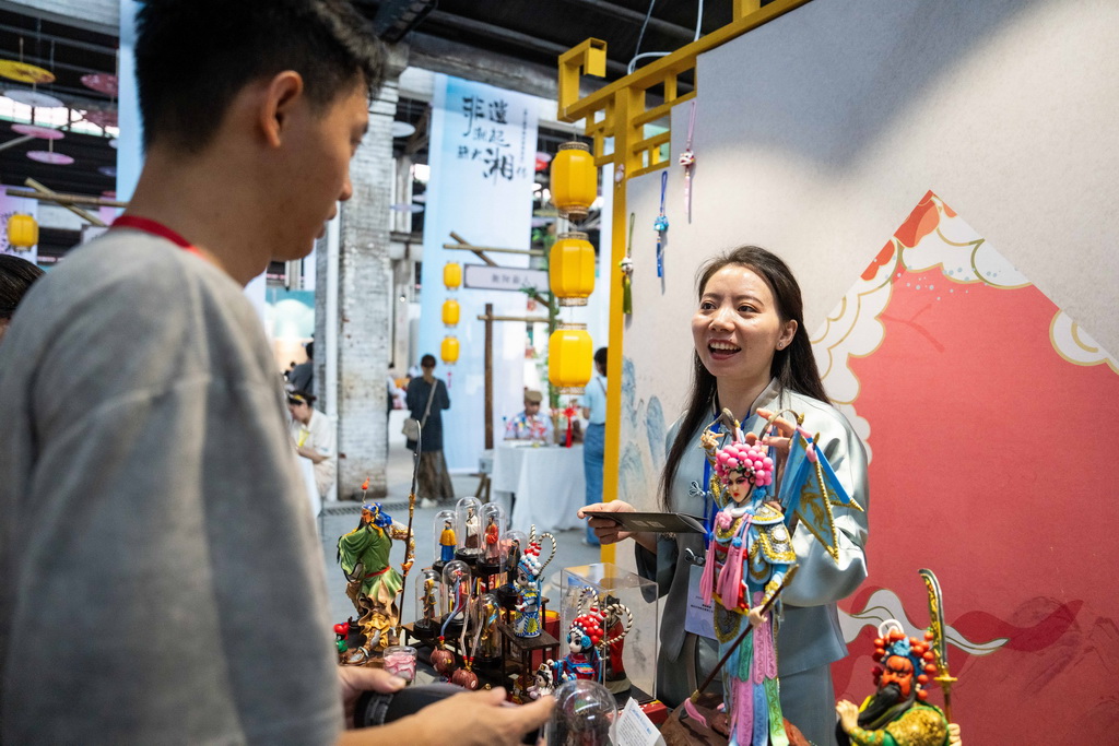 9月21日，在第三屆湖南非遺博覽會上，參展商（右）向觀眾介紹長沙面塑。