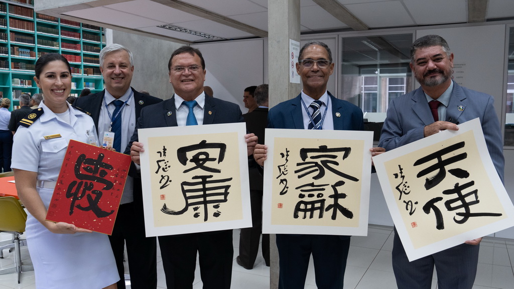 9月23日，在巴西首都巴西利亞高等防務學院舉行的“中國日”活動上，嘉賓手持書畫創作員的作品合影。新華社記者 王天聰 攝