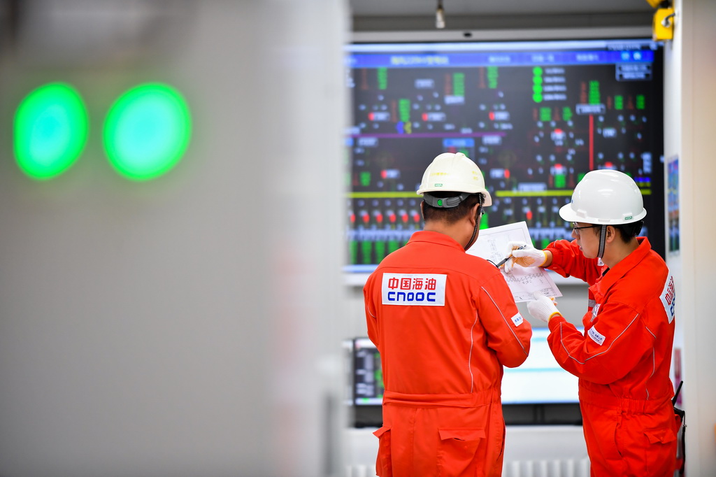 9月25日，工人在渤海油田海上作業平臺配電間交流。
