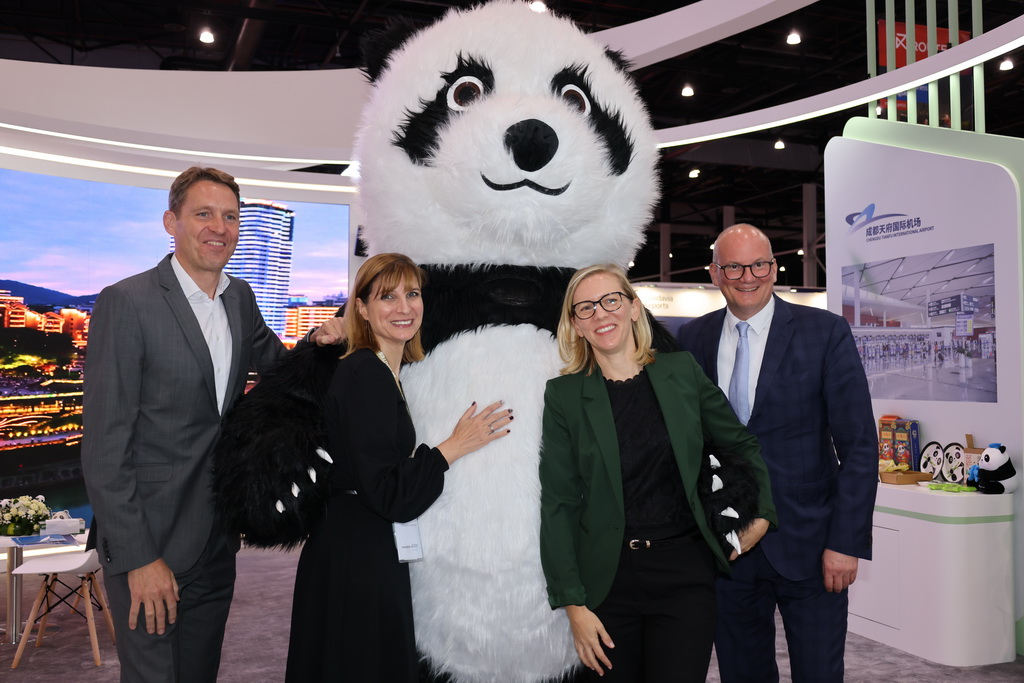 10月6日，在巴林國際會展中心，參會者在成都天府國際機場展位前與熊貓玩偶合影。新華社記者 王海洲 攝