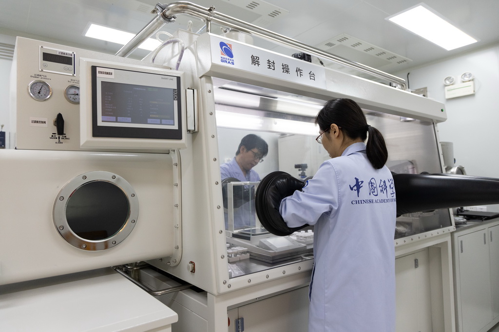 9月24日，科研人員在月球樣品實驗室的解封操作臺上處理嫦娥六號月球樣品。