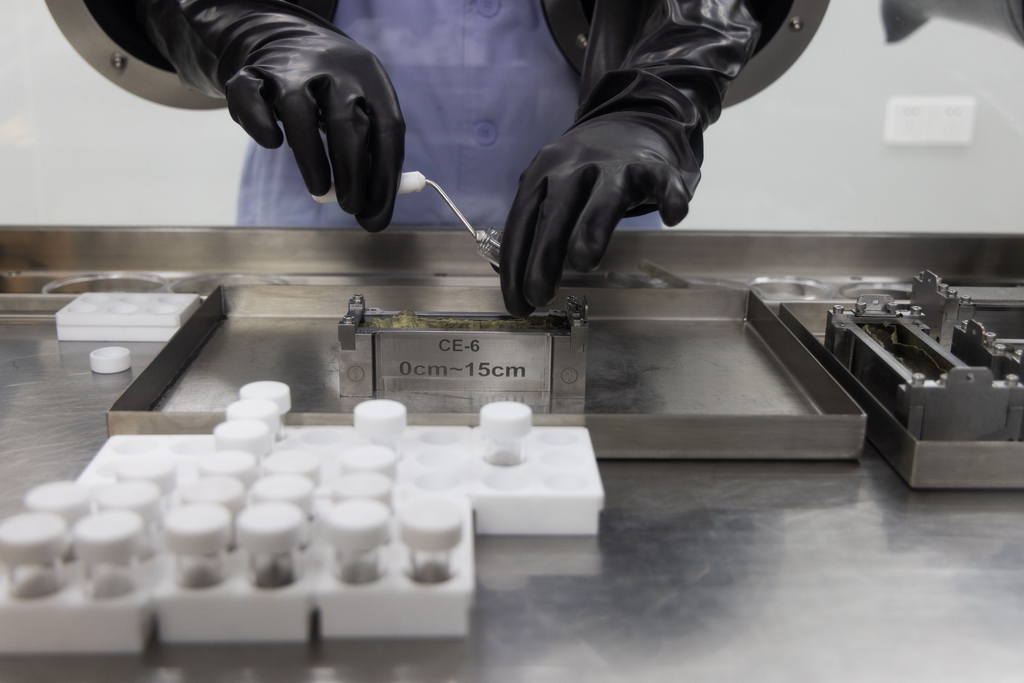 9月24日，科研人員在月球樣品實驗室的解封操作臺上處理嫦娥六號月球樣品。