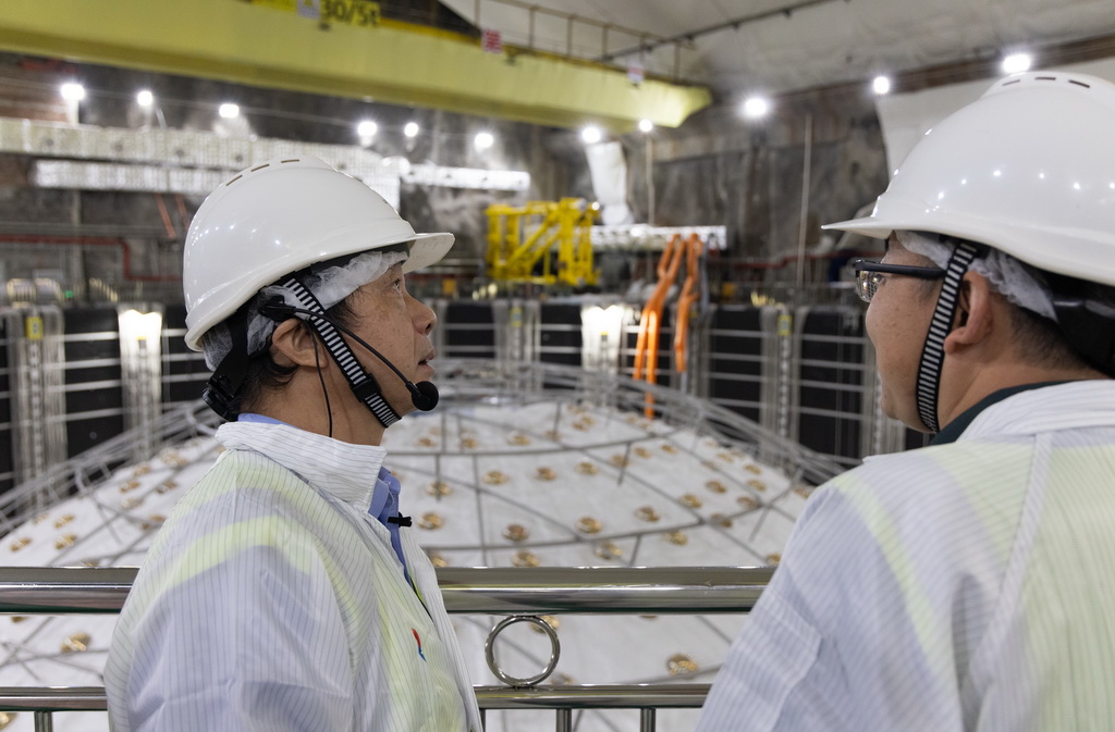 10月10日，江門中微子實驗首席科學家、項目經理王貽芳院士（左）和同事在實驗大廳交流建設進展情況。