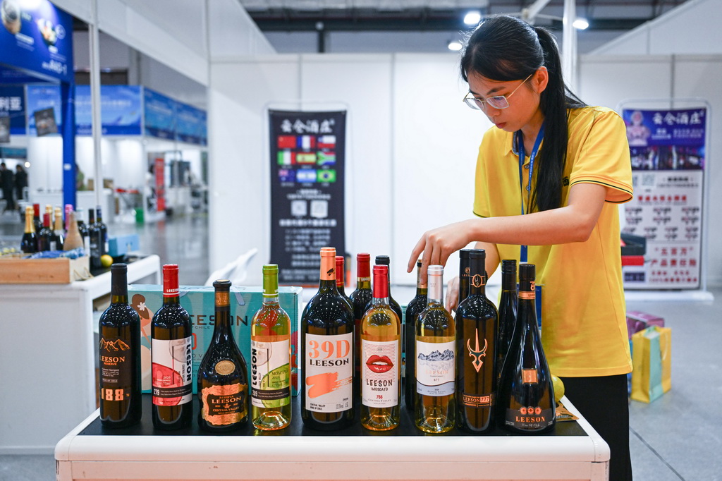 10月17日，在2024第二屆海南國際熱帶食材供應鏈博覽會上，工作人員擺放產自智利的酒品。