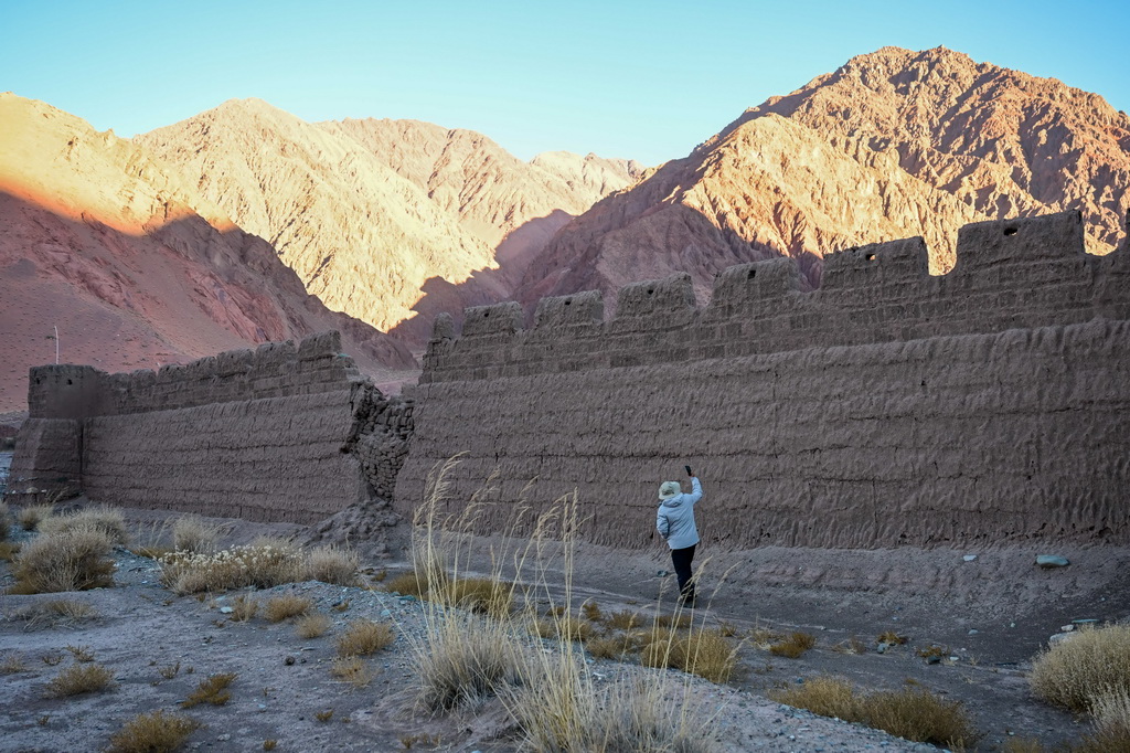 在新疆克孜勒蘇柯爾克孜自治州阿克陶縣木吉鄉，“巡禮中國西極 跨越昆侖天山”多學科科考隊隊員用手機拍攝穆呼老營房遺址（10月21日攝）。新華社記者 丁磊 攝