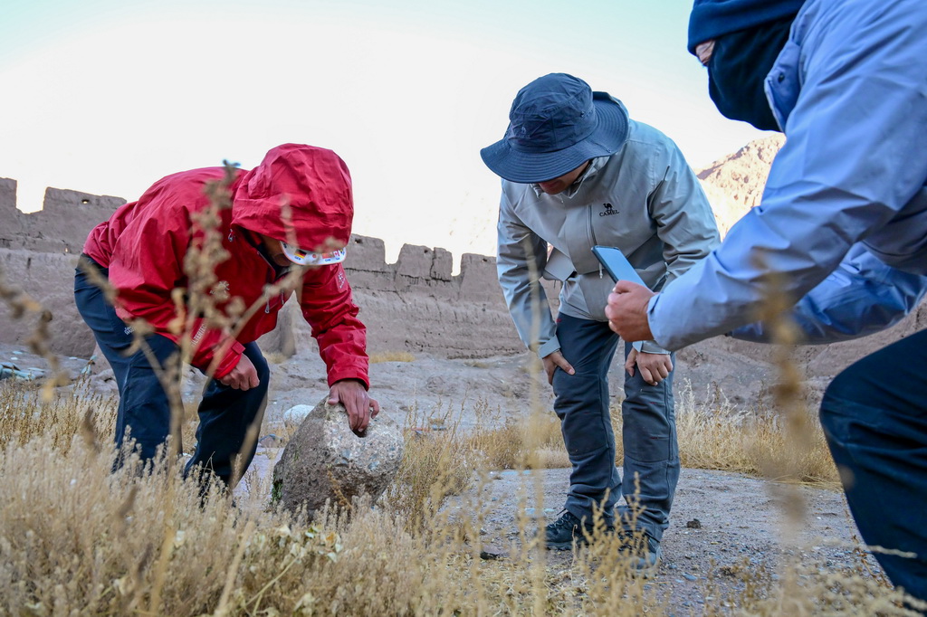 在新疆克孜勒蘇柯爾克孜自治州阿克陶縣木吉鄉穆呼老營房遺址，多學科科考隊員現場查看遺留文物（10月21日攝）。新華社記者 丁磊 攝