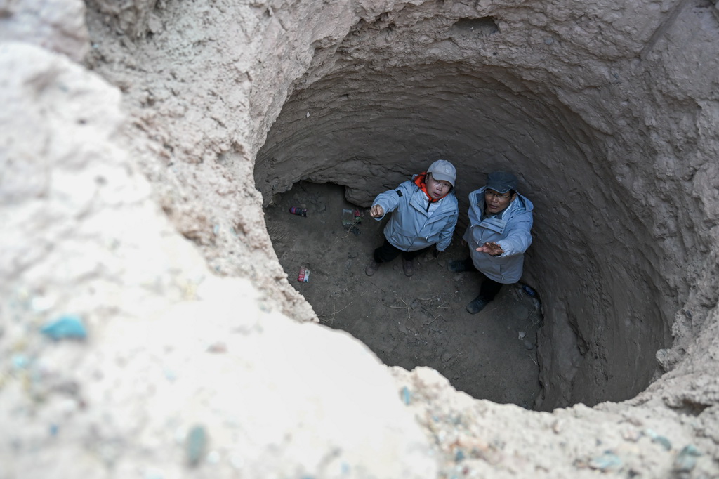 在新疆克孜勒蘇柯爾克孜自治州烏恰縣，考古專家覃大海（右）和新疆古道研究專家駱娟查看一處古代居住遺址（10月26日攝）。新華社記者 丁磊 攝
