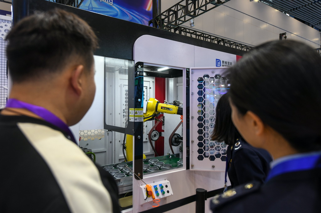 11月6日，在第十二屆中國（綿陽）科技城國際科技博覽會現場，參會者觀看運行中的工業機器人。