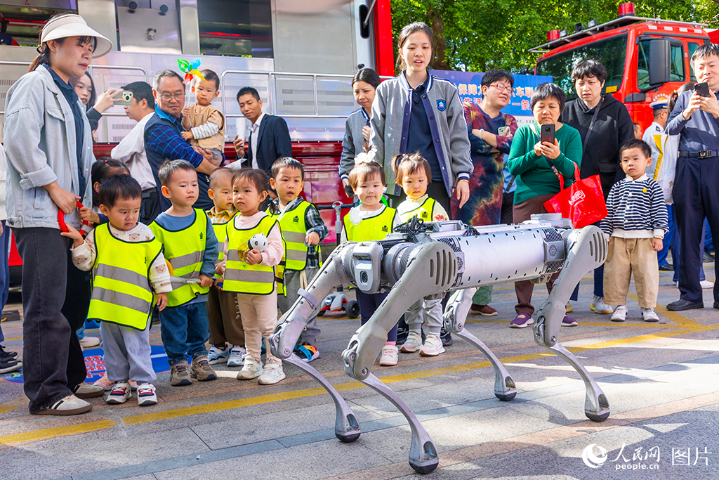 11月8日，福建省消防宣傳月主題活動在福州舉行，圖為現場展示的消防偵查“機器狗”特別吸引小朋友的關注。人民網記者 焦艷攝