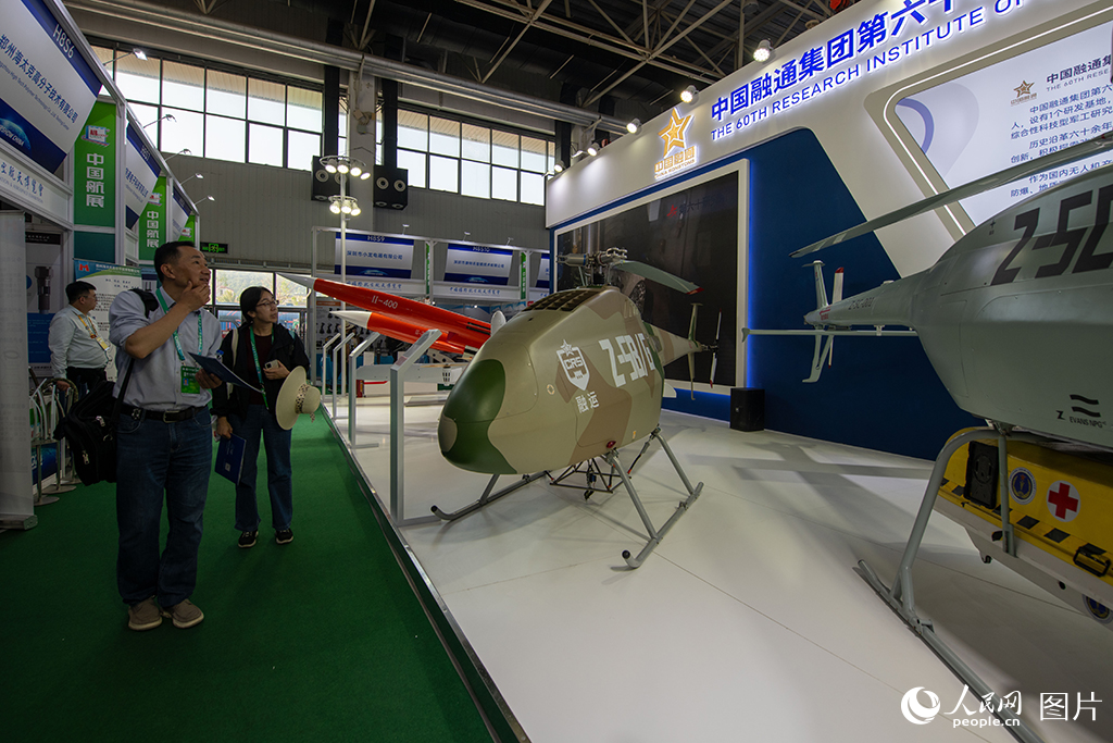 11月12日，在第十五屆中國國際航空航天博覽會低空經濟館，參觀者正在了解中國融通科研院的多款無人機和小型航空發動機。人民網記者 翁奇羽攝