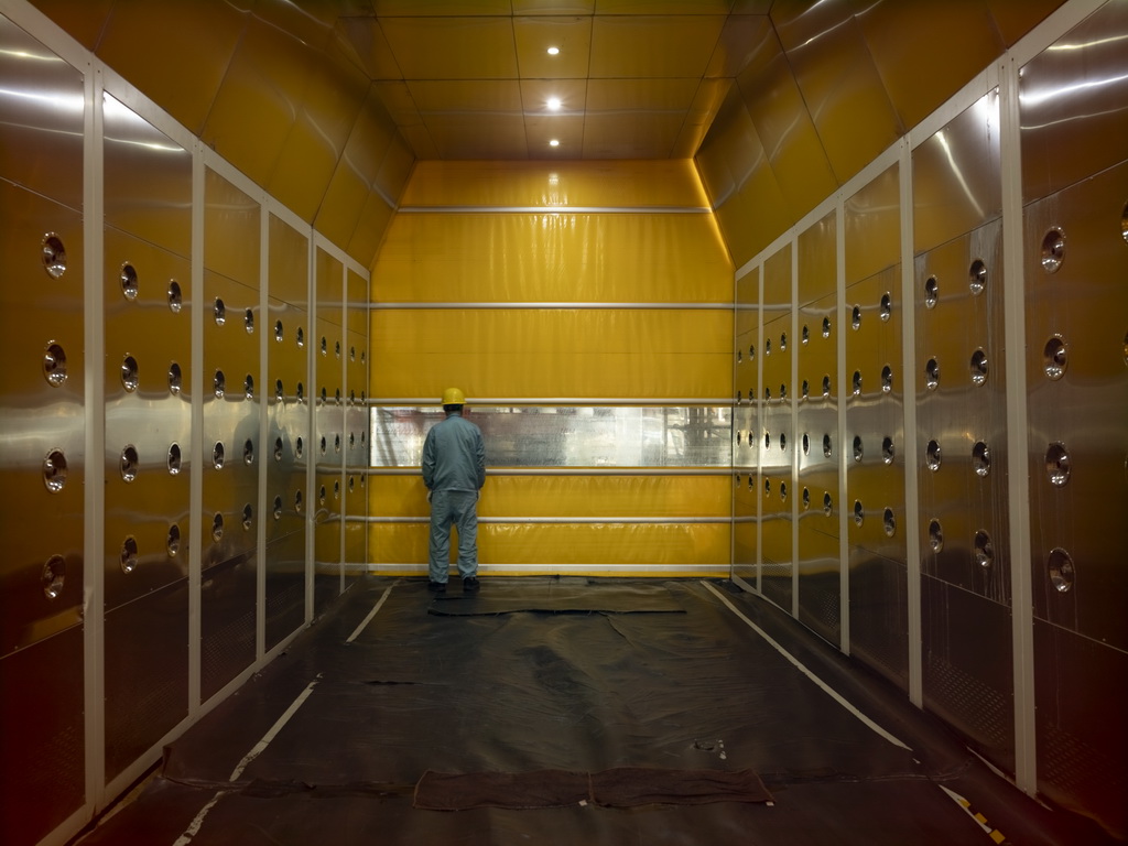 11月22日，一名工作人員在風淋系統里等待進入池底。