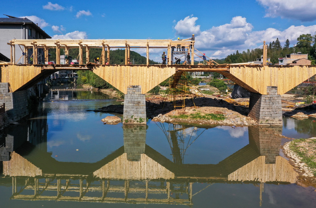在福建省屏南縣長橋鎮，工匠在修復萬安橋時架設廊屋梁柱（2023年11月2日攝，無人機照片）。新華社發（王志凌攝）