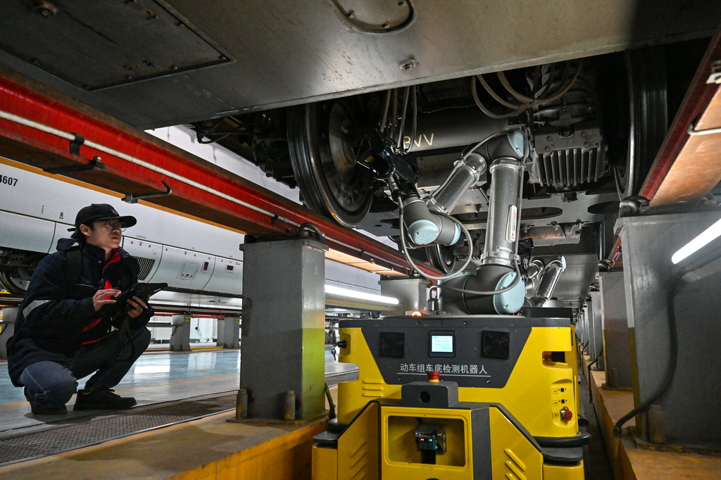 12月19日，在國鐵北京動車段北京北動車運用所，工作人員操縱機器人檢查動車組車底。