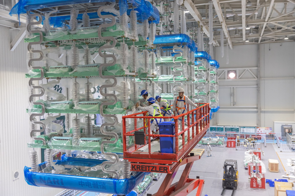 12月19日，在“疆電入渝”特高壓渝北±800千伏換流站工程施工現場，安徽送變電工程有限公司的技術人員在進行國產換流閥的安裝作業。新華社記者 黃偉 攝