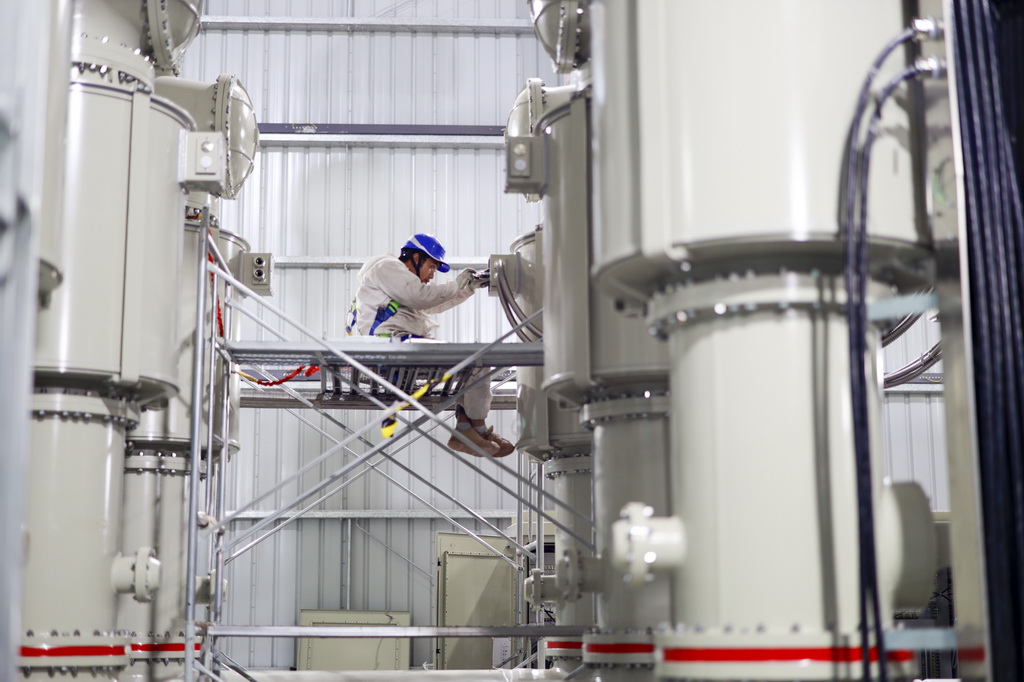 12月19日，在“疆電入渝”特高壓渝北±800千伏換流站工程施工現場，安徽送變電工程有限公司的技術人員在進行國產500千伏電氣設備的安裝作業。新華社記者 劉潺 攝