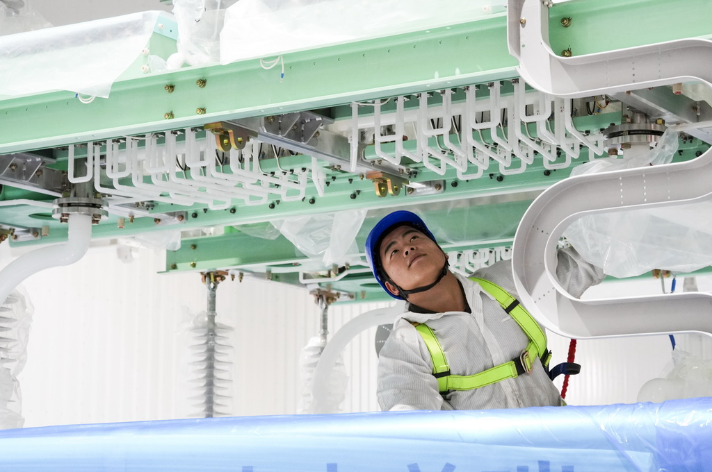 12月19日，在“疆電入渝”特高壓渝北±800千伏換流站工程施工現場，安徽送變電工程有限公司的技術人員在進行國產換流閥的安裝作業。新華社記者 劉潺 攝