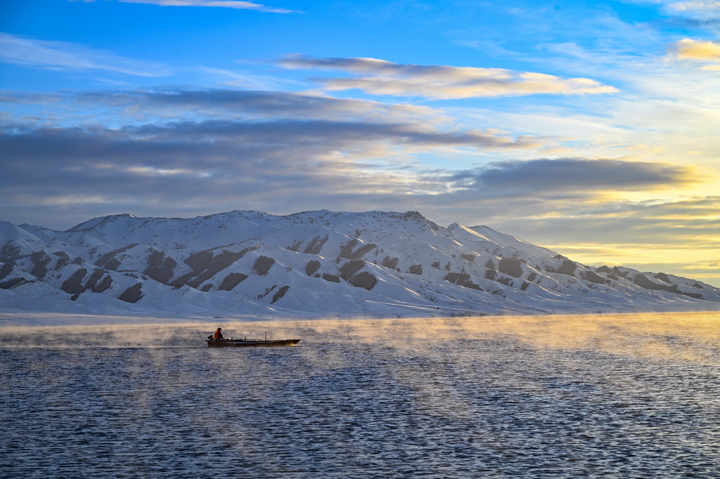 12月23日，一條小船在賽里木湖中駛過。新華社記者 陳朔 攝