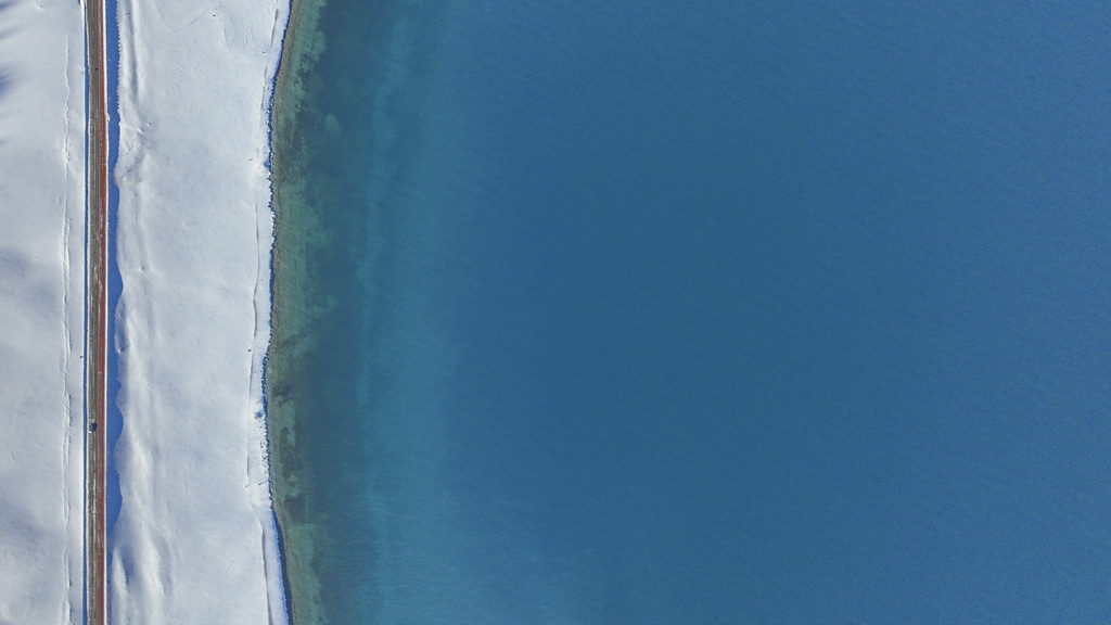 這是12月23日拍攝的賽里木湖景色，陽光下湖水呈現不同顏色（無人機照片）。新華社記者 陳朔 攝