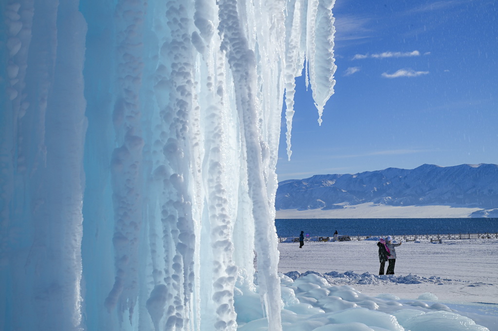 12月23日，游客在賽里木湖邊游覽。新華社記者 陳朔 攝
