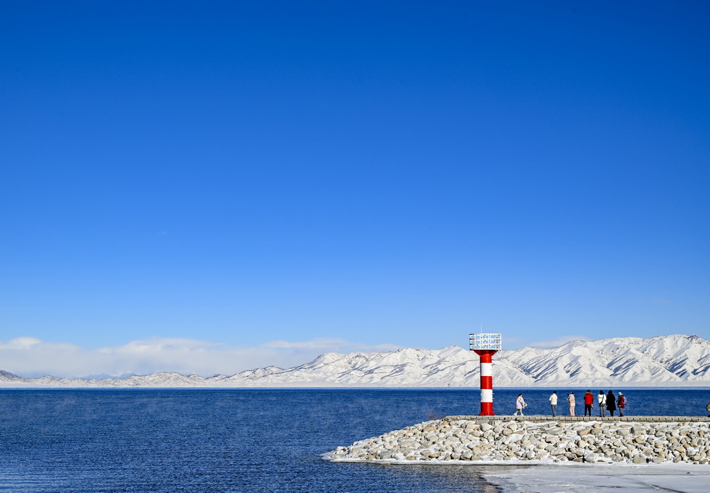 12月23日，游客在賽里木湖邊游覽。新華社記者 陳朔 攝
