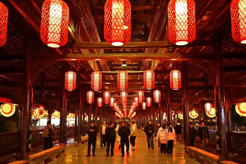 12月28日晚，湖北省宣恩縣城的風雨橋上燈籠高掛，人們觀光游覽。新華社發（宋文攝）