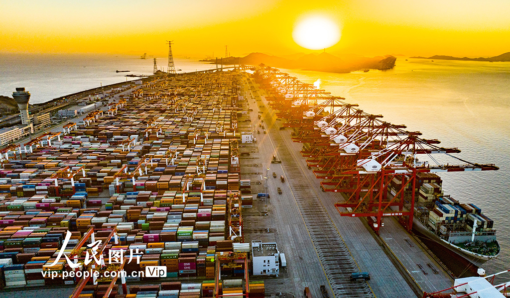 2025年1月1日，迎著新年第一縷陽光，上海港洋山深水港區自動化碼頭，橋吊林立、多艘大型集裝箱貨輪正在進行裝卸作業。計海新攝（人民圖片網）