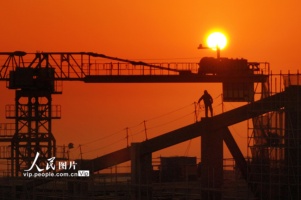 2025年1月1日，工人在江蘇省蘇州市吳江區太湖新城一處建筑工地進行高空作業。眾多勞動者放棄休息，堅守崗位，在工作崗位上迎接新年第一縷陽光的到來。許叢軍攝（人民圖片網）