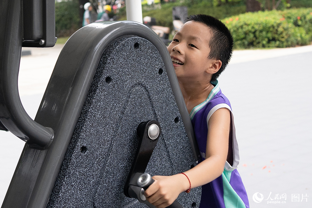 2024年8月7日，深圳市光明區室外智能健身房，小朋友在體驗健身設施。人民網 江佳玲攝