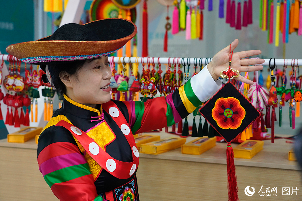 2024年9月13日，位于青?；ブ那嗬C（盤繡）產業基地內，工作人員介紹盤繡產品，民族文化自信溢于言表。土族盤繡已成為當地的特色產業、富民產業，土族阿姑們拿起了繡花針，繡出了新天地。人民網記者 楊啟紅攝