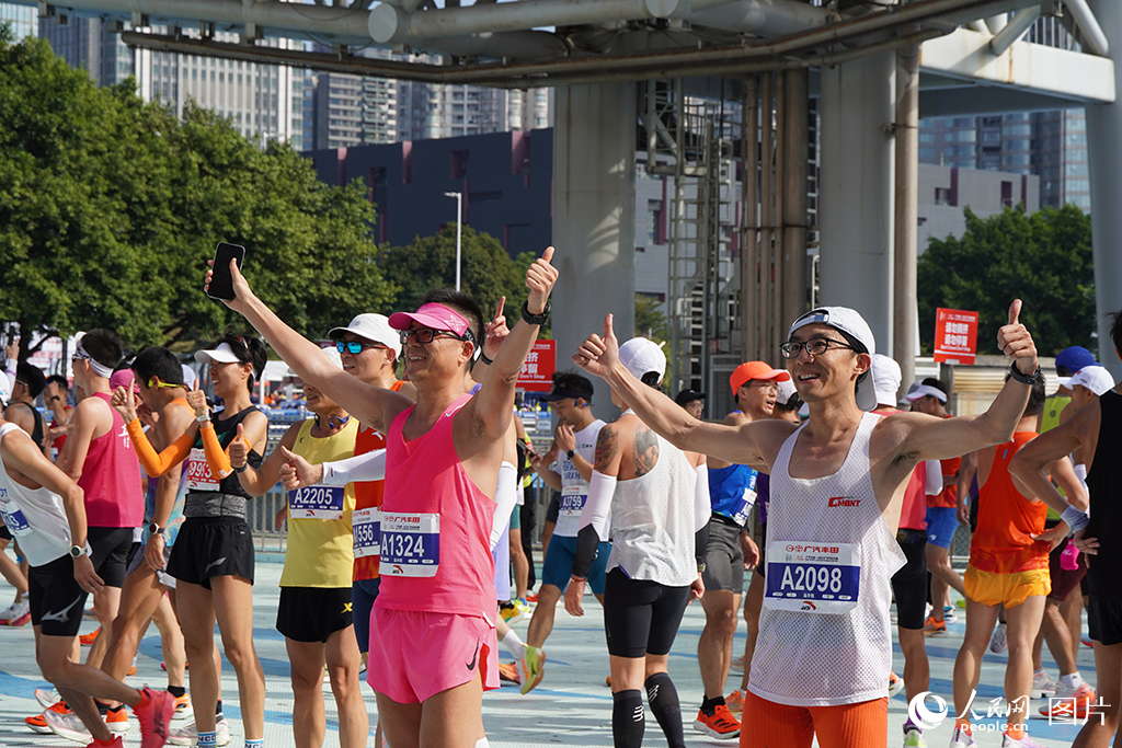 2024年12月8日，在廣州馬拉松賽現場，選手們完賽后合影留念，表達喜悅。人民網 王雅蝶攝