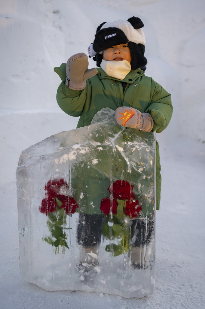 1月5日，在哈爾濱冰雪大世界園區，小朋友在“冰封玫瑰”景觀旁游玩。新華社記者 謝劍飛 攝