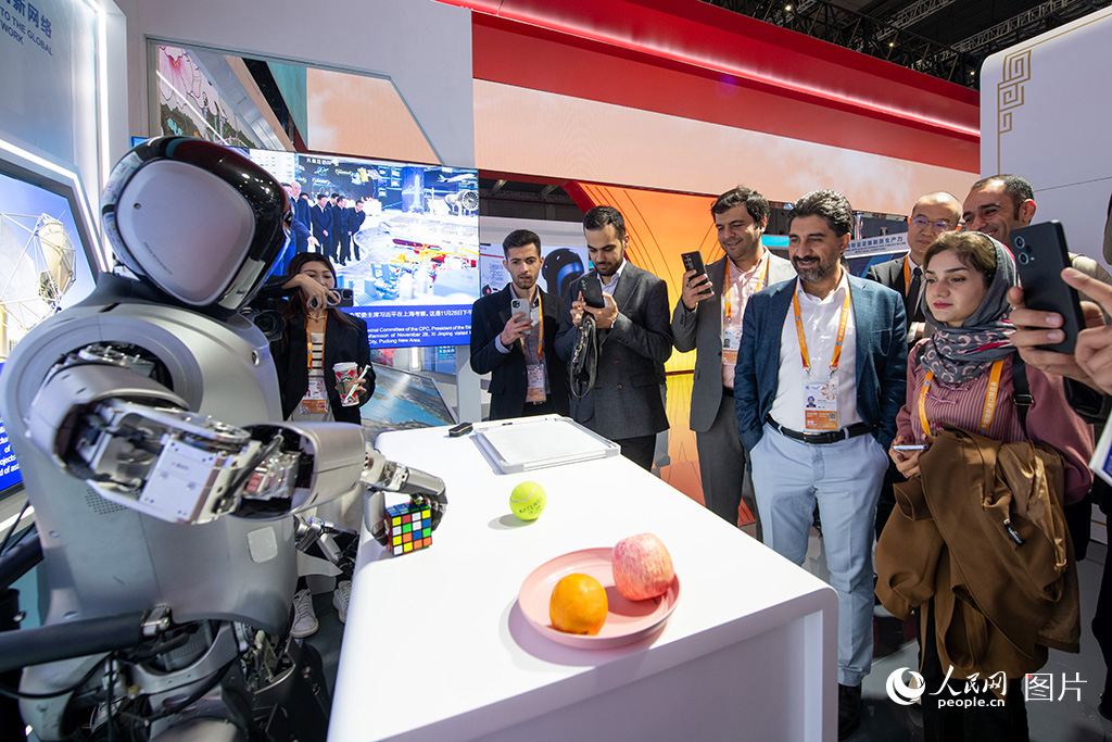 2024年11月6日，在第七屆進博會中國館，人形機器人吸引眾多外國參展商目光。人民網記者 翁奇羽攝